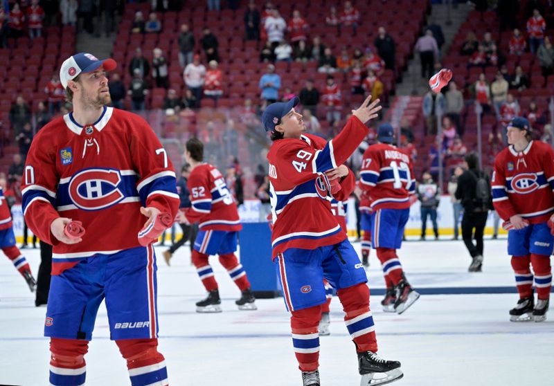 Apr 16, 2024; Montreal, Quebec, CAN; Montreal Canadiens forward Tanner Pearson (70) and teammates including forward Rafael Harvey-Pinard (49) throw souvenirs to fans after a game against the Detroit Red Wings at the Bell Centre. Mandatory Credit: Eric Bolte-USA TODAY Sports