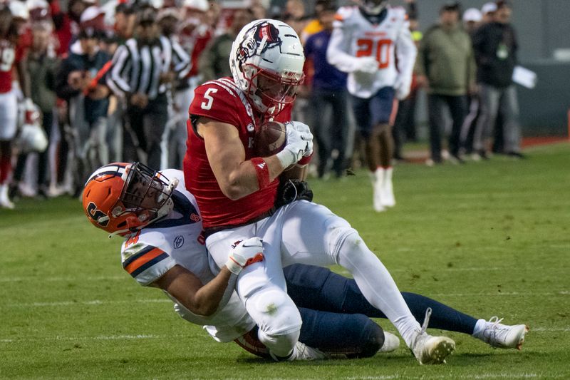 Nov 20, 2021; Raleigh, North Carolina, USA; North Carolina State Wolfpack wide receiver Thayer Thomas (5) is brought down by Syracuse Orange defensive back Jason Simmons (14) after a reception during the second half at Carter-Finley Stadium. Mandatory Credit: William Howard-USA TODAY Sports