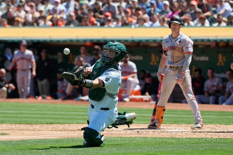 Aug 18, 2024; Oakland, California, USA; Oakland Athletics catcher Shea Langeliers (23) slides to catch a popup bunt hit by San Francisco Giants outfielder Mike Yastrzemski (5) during the fifth inning at Oakland-Alameda County Coliseum. Mandatory Credit: Robert Edwards-USA TODAY Sports