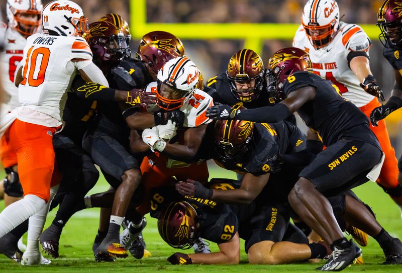 Sep 9, 2023; Tempe, Arizona, USA; Oklahoma State Cowboys running back Elijah Collins (24) is tackled by the Arizona State Sun Devils defense in the first half at Mountain America Stadium. Mandatory Credit: Mark J. Rebilas-USA TODAY Sports