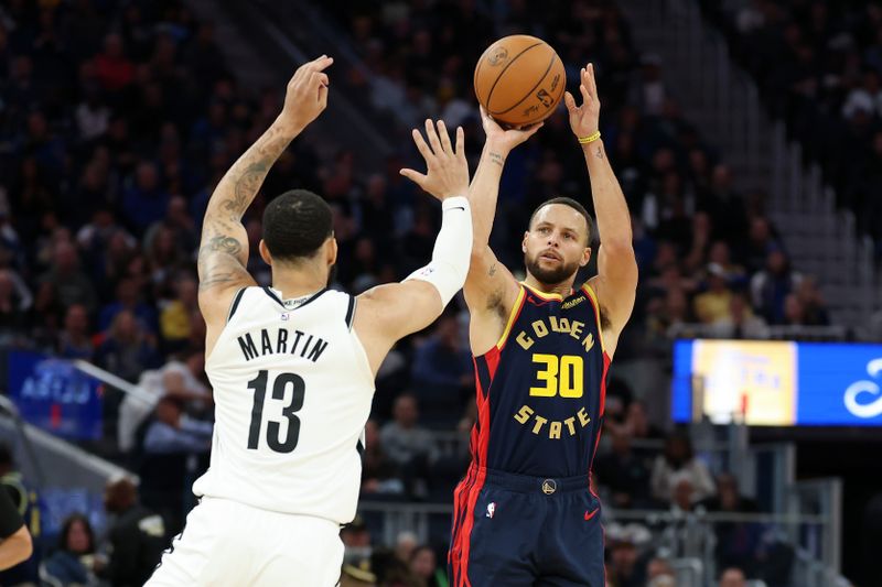 SAN FRANCISCO, CALIFORNIA - NOVEMBER 25: Stephen Curry #30 of the Golden State Warriors shoots over Tyrese Martin #13 of the Brooklyn Nets in the second half at Chase Center on November 25, 2024 in San Francisco, California. NOTE TO USER: User expressly acknowledges and agrees that, by downloading and/or using this photograph, user is consenting to the terms and conditions of the Getty Images License Agreement.   (Photo by Ezra Shaw/Getty Images)