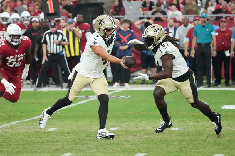 New Orleans Saints quarterback Derek Carr (4) hands off to running back Alvin Kamara (41) in the first half of a preseason NFL football game against the Arizona Cardinals, Saturday, Aug. 10, 2024, in Glendale, Ariz. (AP Photo/Rick Scuteri)