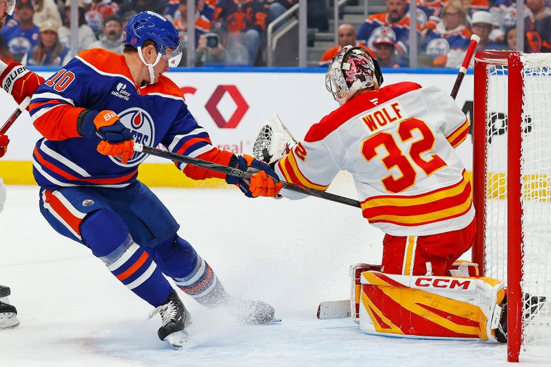 Oct 8, 2025; Edmonton, Alberta, CAN; Calgary Flames goaltender Dustin Wolf (32) makes a save on a shot by Edmonton Oilers forward Trent Frederic (10) during the first period at Rogers Place. Mandatory Credit: Perry Nelson-Imagn Images