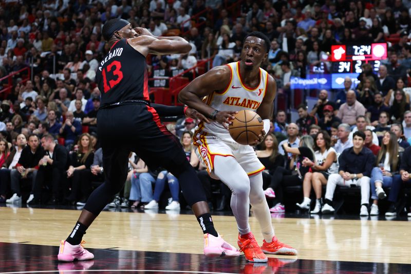 MIAMI, FLORIDA - JANUARY 19: Onyeka Okongwu #17 of the Atlanta Hawks drives against Bam Adebayo #13 of the Miami Heat during the second quarter of the game at Kaseya Center on January 19, 2024 in Miami, Florida. NOTE TO USER: User expressly acknowledges and agrees that, by downloading and or using this photograph, User is consenting to the terms and conditions of the Getty Images License Agreement. (Photo by Megan Briggs/Getty Images)