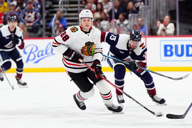 Mar 10, 2025; Denver, Colorado, USA; Chicago Blackhawks center Colton Dach (28) controls the puck in the first period against the Colorado Avalanche at Ball Arena. Mandatory Credit: Ron Chenoy-Imagn Images