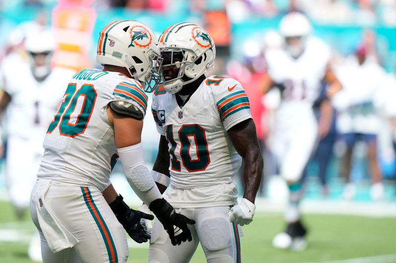 Miami Dolphins wide receiver Tyreek Hill (10) celebrates a run with fullback Alec Ingold (30) during the first half of an NFL football game against the New England Patriots, Sunday, Oct. 29, 2023, in Miami Gardens, Fla. (AP Photo/Wilfredo Lee)