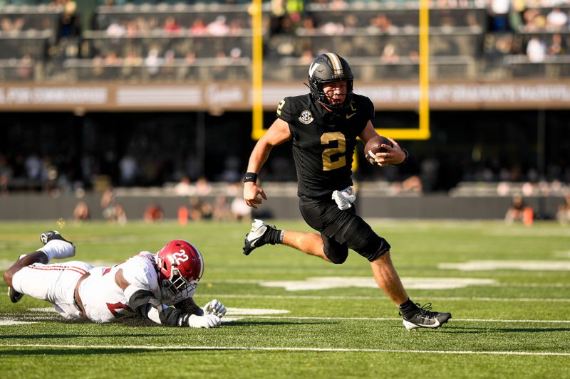 Oct 5, 2024; Nashville, Tennessee, USA;  Vanderbilt Commodores quarterback Diego Pavia (2) breaks the tackle of Alabama Crimson Tide defensive lineman LT Overton (22) during the first half at FirstBank Stadium. Mandatory Credit: Steve Roberts-Imagn Images