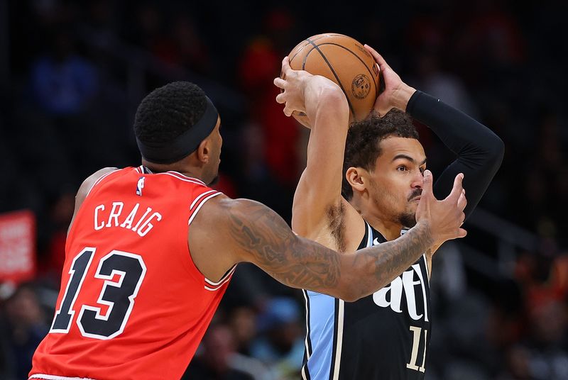 ATLANTA, GEORGIA - FEBRUARY 12:  Trae Young #11 of the Atlanta Hawks is defended by Torrey Craig #13 of the Chicago Bulls during the first quarter at State Farm Arena on February 12, 2024 in Atlanta, Georgia.  NOTE TO USER: User expressly acknowledges and agrees that, by downloading and/or using this photograph, user is consenting to the terms and conditions of the Getty Images License Agreement.  (Photo by Kevin C. Cox/Getty Images)