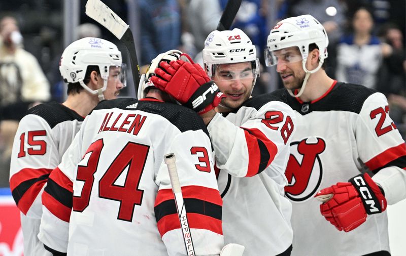 Apr 11, 2024; Toronto, Ontario, CAN; New Jersey Devils goalie Jake Allen (34) is greeted by forward Timo Meier (28) and team mates as they celebrate a win over the Toronto Maple Leafs at Scotiabank Arena. Mandatory Credit: Dan Hamilton-USA TODAY Sports