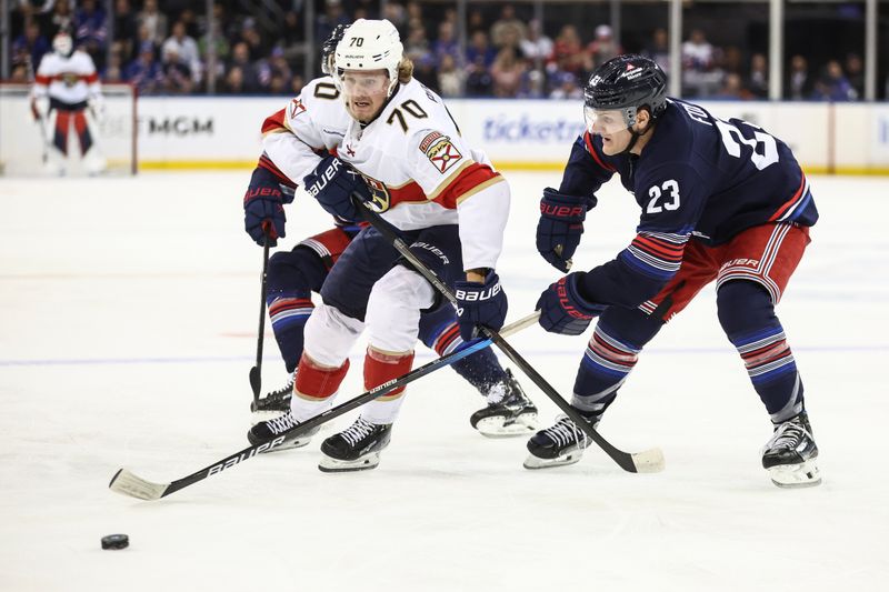 Oct 24, 2024; New York, New York, USA;  Florida Panthers center Jesper Boqvist (70) and New York Rangers defenseman Adam Fox (23) battle for control of the puck in the third period at Madison Square Garden. Mandatory Credit: Wendell Cruz-Imagn Images