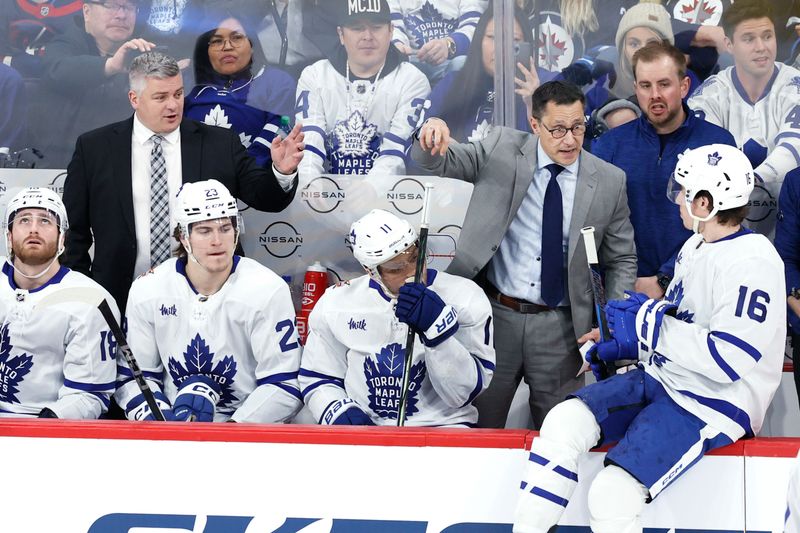 Jan 27, 2024; Winnipeg, Manitoba, CAN; Toronto Maple Leafs head coach Sheldon Keefe and assistant coach Guy Boucher discuss a play with Toronto Maple Leafs right wing Mitchell Marner (16) in the third period against the Winnipeg Jets at Canada Life Centre. Mandatory Credit: James Carey Lauder-USA TODAY Sports