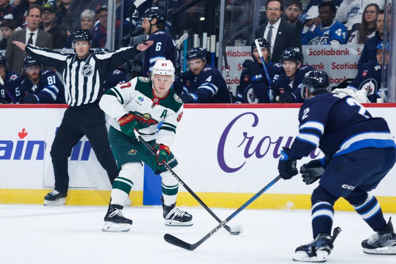 Oct 13, 2024; Winnipeg, Manitoba, CAN;  Minnesota Wild forward Kirill Kaprizov (97) skates in on Winnipeg Jets defenseman Dylan DeMelo (2) during the first period at Canada Life Centre. Mandatory Credit: Terrence Lee-Imagn Images