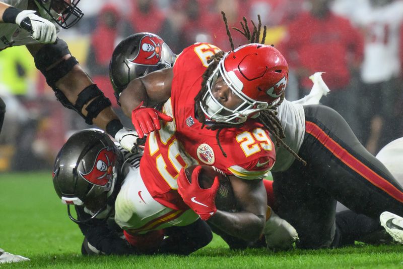 Kansas City Chiefs running back Kareem Hunt (29) is tackled by Tampa Bay Buccaneers players during the second half of an NFL football game, Monday, Nov. 4, 2024 in Kansas City, Mo. The Chiefs defeated the Buccaneers, 30-24. (AP Photo/Reed Hoffmann)