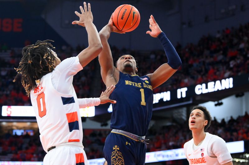 Jan 14, 2023; Syracuse, New York, USA; Notre Dame Fighting Irish guard J.J. Starling (1) drives to the basket between Syracuse Orange forward Chris Bell (0) and center Jesse Edwards (right) during the second half at the JMA Wireless Dome. Mandatory Credit: Rich Barnes-USA TODAY Sports