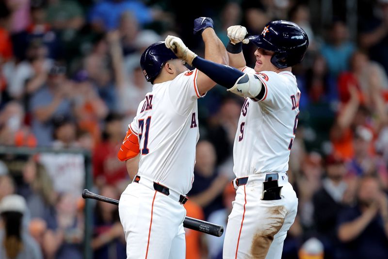 May 28, 2025; Houston, Texas, USA; Houston Astros designated hitter Zach Dezenzo (9) is congratulated by Houston Astros pinch hitter Yainer Diaz (21) after hitting a home run to center field against the Athletics during the seventh inning at Daikin Park. Mandatory Credit: Erik Williams-Imagn Images