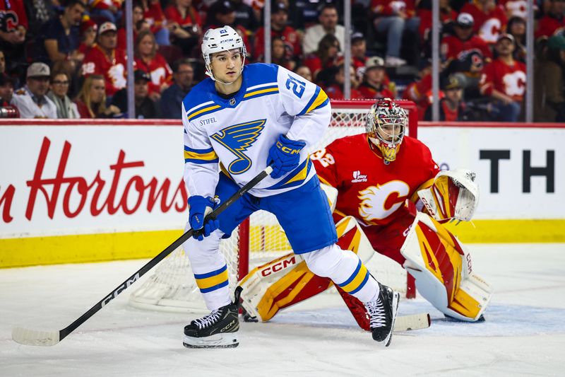 Oct 11, 2025; Calgary, Alberta, CAN; St. Louis Blues right wing Jimmy Snuggerud (21) screens in front of Calgary Flames goaltender Dustin Wolf (32) during the first period at Scotiabank Saddledome. Mandatory Credit: Sergei Belski-Imagn Images