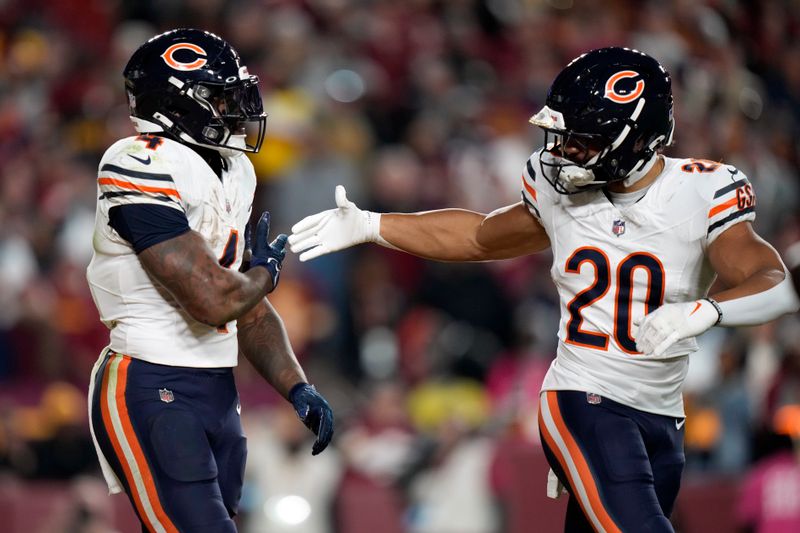 Chicago Bears running back D'Andre Swift (4) is congratulated by Travis Homer (20) after Swift scored a touchdown against the Washington Commanders in the second half of an NFL football game Sunday, Oct. 27, 2024, in Landover, Md. (AP Photo/Stephanie Scarbrough)