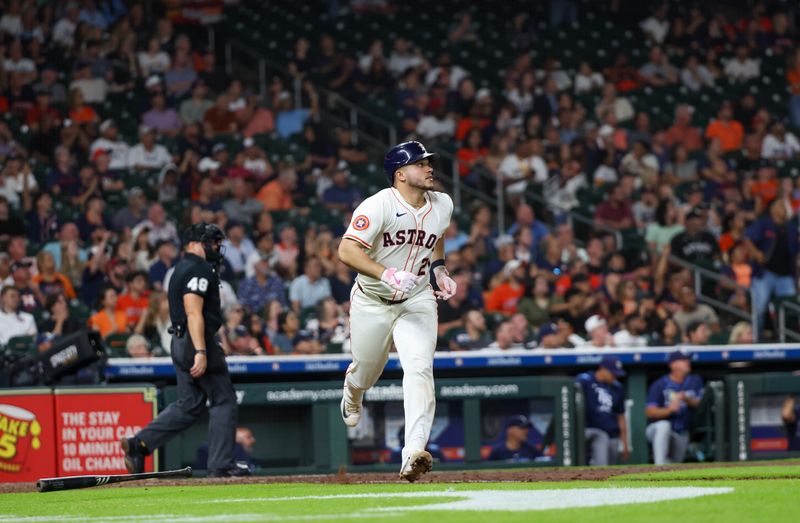May 29, 2025; Houston, Texas, USA;  Houston Astros catcher Yainer Diaz (21) hits a home run against the Tampa Bay Rays in the fifth inning at Daikin Park. Mandatory Credit: Thomas Shea-Imagn Images