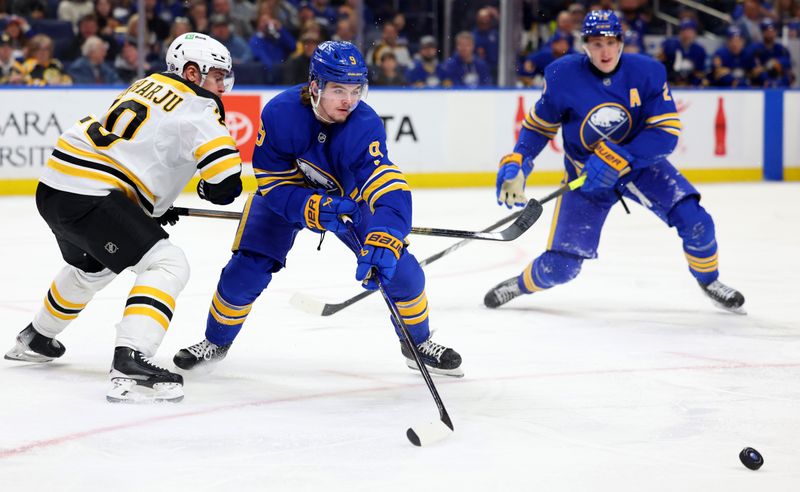 Apr 6, 2025; Buffalo, New York, USA;  Buffalo Sabres left wing Zach Benson (9) makes a pass as Boston Bruins defenseman Henri Jokiharju (20) defends during the second period at KeyBank Center. Mandatory Credit: Timothy T. Ludwig-Imagn Images