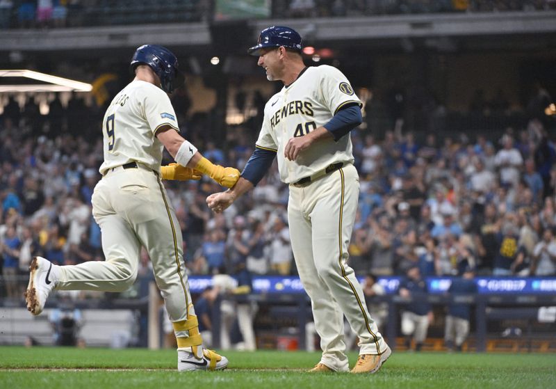 Aug 14, 2024; Milwaukee, Wisconsin, USA; Milwaukee Brewers first base Jake Bauers (9) is congratulated by Milwaukee Brewers third base coach Jason Lane (40) after hitting a home run against the Los Angeles Dodgers in the second inning at American Family Field. Mandatory Credit: Michael McLoone-USA TODAY Sports