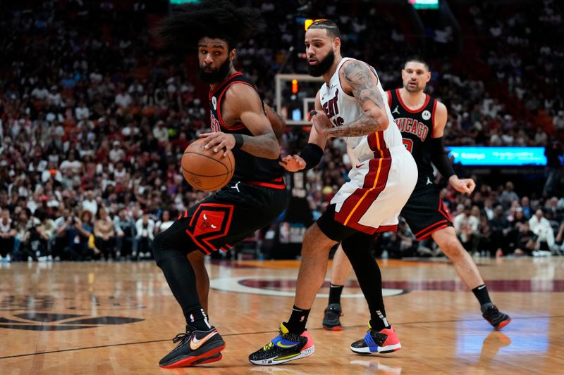 MIAMI, FLORIDA - APRIL 19: Coby White #0 of the Chicago Bulls dribbles the ball against Caleb Martin #16 of the Miami Heat in the third quarter during the Play-In Tournament at Kaseya Center on April 19, 2024 in Miami, Florida. NOTE TO USER: User expressly acknowledges and agrees that, by downloading and or using this photograph, User is consenting to the terms and conditions of the Getty Images License Agreement. (Photo by Rich Storry/Getty Images)