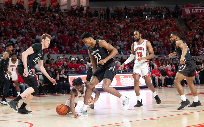 Jan 28, 2023; Houston, Texas, USA; Houston Cougars guard Tramon Mark (12) loses the ball against Cincinnati Bearcats forward Ody Oguama (33) in the first half at Fertitta Center. Mandatory Credit: Thomas Shea-USA TODAY Sports