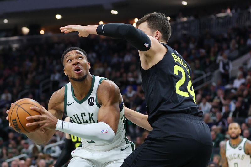 MILWAUKEE, WISCONSIN - NOVEMBER 07: Giannis Antetokounmpo #34 of the Milwaukee Bucks is defended by Walker Kessler #24 of the Utah Jazz during the first half of a game at Fiserv Forum on November 07, 2024 in Milwaukee, Wisconsin.  NOTE TO USER: User expressly acknowledges and agrees that, by downloading and or using this photograph, User is consenting to the terms and conditions of the Getty Images License Agreement. (Photo by Stacy Revere/Getty Images)