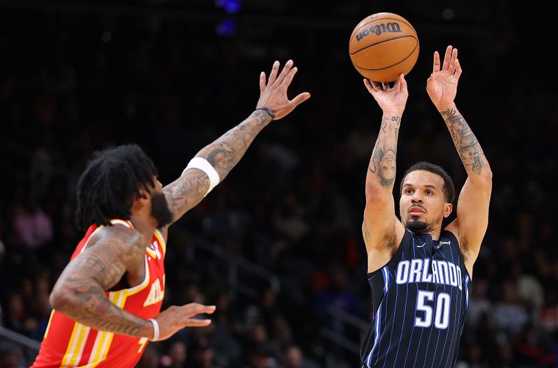 ATLANTA, GEORGIA - FEBRUARY 25:  Cole Anthony #50 of the Orlando Magic attempts a three-point basket against Saddiq Bey #41 of the Atlanta Hawks during the second quarter at State Farm Arena on February 25, 2024 in Atlanta, Georgia.  NOTE TO USER: User expressly acknowledges and agrees that, by downloading and/or using this photograph, user is consenting to the terms and conditions of the Getty Images License Agreement.  (Photo by Kevin C. Cox/Getty Images)