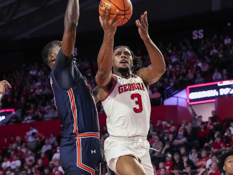 Jan 4, 2023; Athens, Georgia, USA; Georgia Bulldogs guard Kario Oquendo (3) drives to the basket against Auburn Tigers forward Jaylin Williams (2) during the second half at Stegeman Coliseum. Mandatory Credit: Dale Zanine-USA TODAY Sports