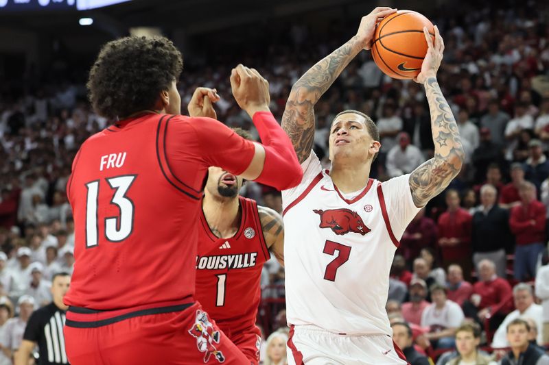 Dec 3, 2025; Fayetteville, Arkansas, USA; Arkansas Razorbacks forward Trevon Brazile (7) drives to the basket as Louisville Cardinals guard J’Vonne Hadley (1) defends during the first half at Bud Walton Arena. Mandatory Credit: Nelson Chenault-Imagn Images