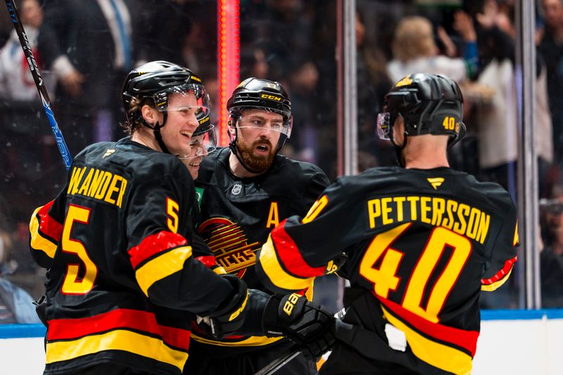 Jan 21, 2026; Vancouver, British Columbia, CAN; Vancouver Canucks defenseman Tom Willander (5) and  forward Jake DeBrusk (74) and forward Elias Pettersson (40) and defenseman Filip Hronek (17) celebrate Hronek’s goal against the Washington Capitals in the second period at Rogers Arena. Mandatory Credit: Bob Frid-Imagn Images