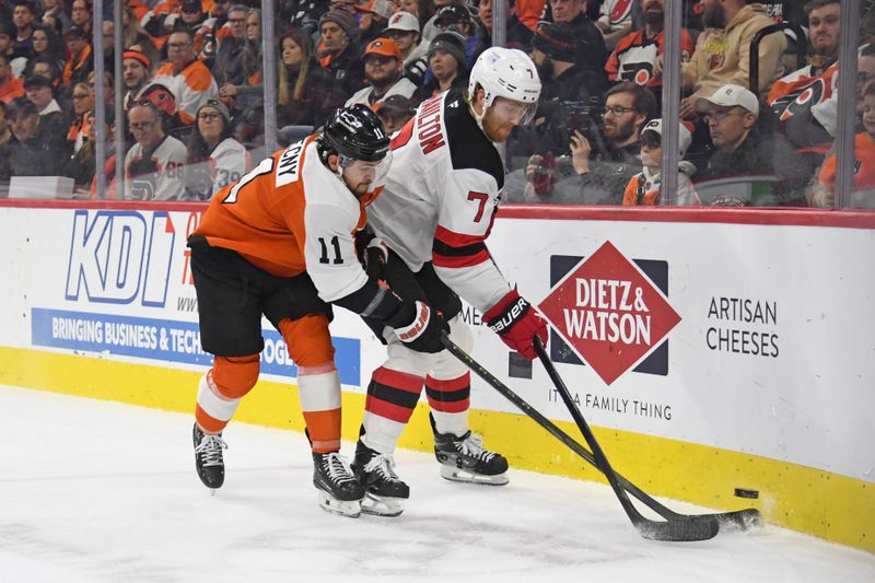 Jan 27, 2025; Philadelphia, Pennsylvania, USA; Philadelphia Flyers right wing Travis Konecny (11) and New Jersey Devils defenseman Dougie Hamilton (7) battle for the puck during the first period at Wells Fargo Center. Mandatory Credit: Eric Hartline-Imagn Images