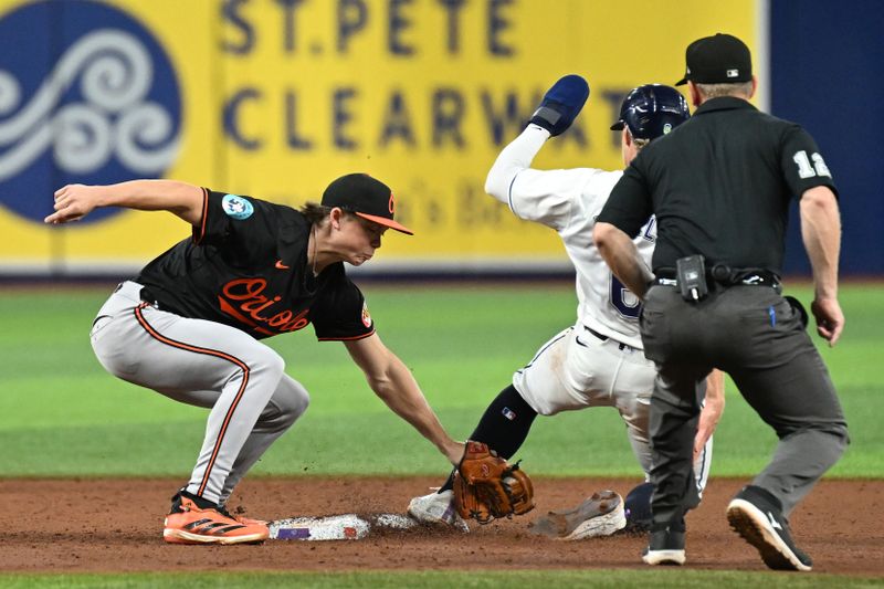 Aug 9, 2024; St. Petersburg, Florida, USA; Baltimore Orioles second baseman Jackson Holliday (7) attempts to tag out Tampa Bay Rays shortstop Taylor Walls (6) in the fifth inning at Tropicana Field. Mandatory Credit: Jonathan Dyer-USA TODAY Sports