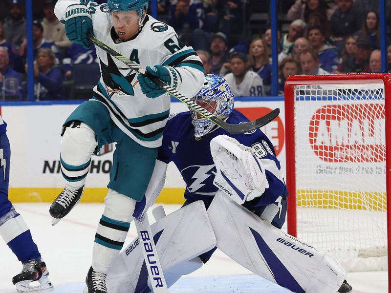 Dec 5, 2024; Tampa, Florida, USA; San Jose Sharks center Mikael Granlund (64) jumps in front of Tampa Bay Lightning goaltender Andrei Vasilevskiy (88) during the second period at Amalie Arena. Mandatory Credit: Kim Klement Neitzel-Imagn Images