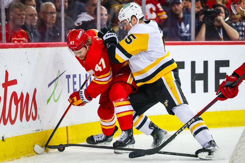 Jan 21, 2026; Calgary, Alberta, CAN; Calgary Flames center Connor Zary (47) and Pittsburgh Penguins defenseman Ryan Shea (5) battle for the puck during the second period at Scotiabank Saddledome. Mandatory Credit: Sergei Belski-Imagn Images