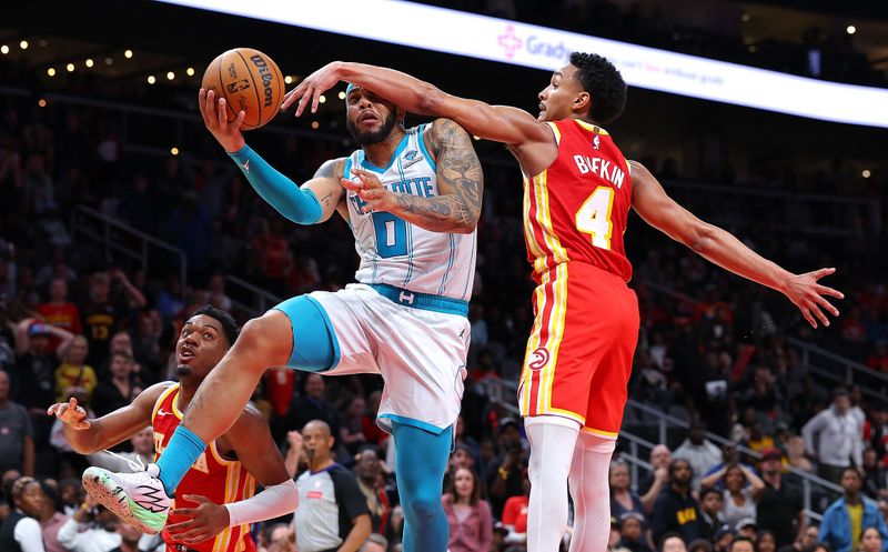 ATLANTA, GEORGIA - APRIL 10:  Miles Bridges #0 of the Charlotte Hornets scores the game-winning basket as he drives against Kobe Bufkin #4 of the Atlanta Hawks during the fourth quarter at State Farm Arena on April 10, 2024 in Atlanta, Georgia.  NOTE TO USER: User expressly acknowledges and agrees that, by downloading and/or using this photograph, user is consenting to the terms and conditions of the Getty Images License Agreement.  (Photo by Kevin C. Cox/Getty Images)