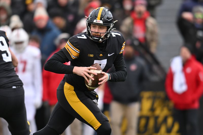 Nov 12, 2022; Iowa City, Iowa, USA; Iowa Hawkeyes quarterback Spencer Petras (7) rolls out against the Wisconsin Badgers during the first quarter at Kinnick Stadium. Mandatory Credit: Jeffrey Becker-USA TODAY Sports