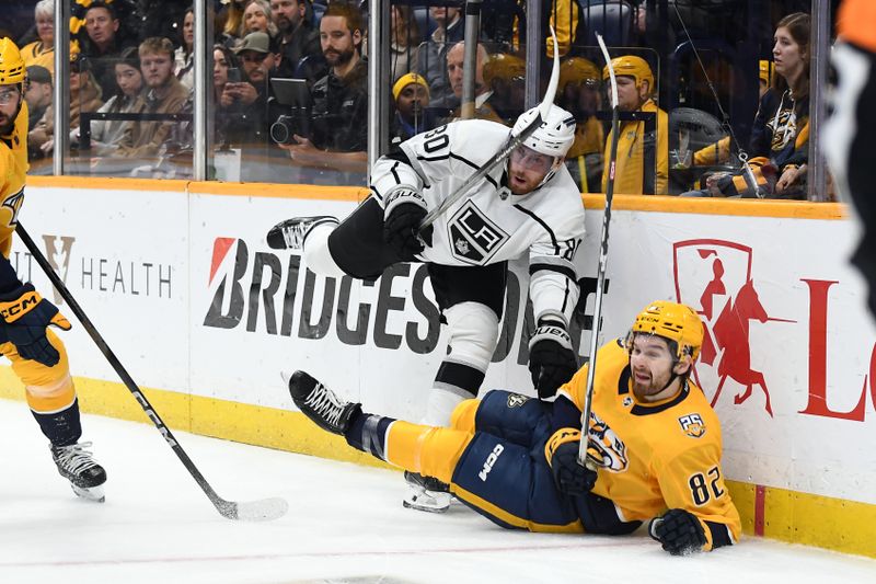 Jan 31, 2024; Nashville, Tennessee, USA; Nashville Predators center Tommy Novak (82) falls as he is hit by Los Angeles Kings center Pierre-Luc Dubois (80) during the second period at Bridgestone Arena. Mandatory Credit: Christopher Hanewinckel-USA TODAY Sports