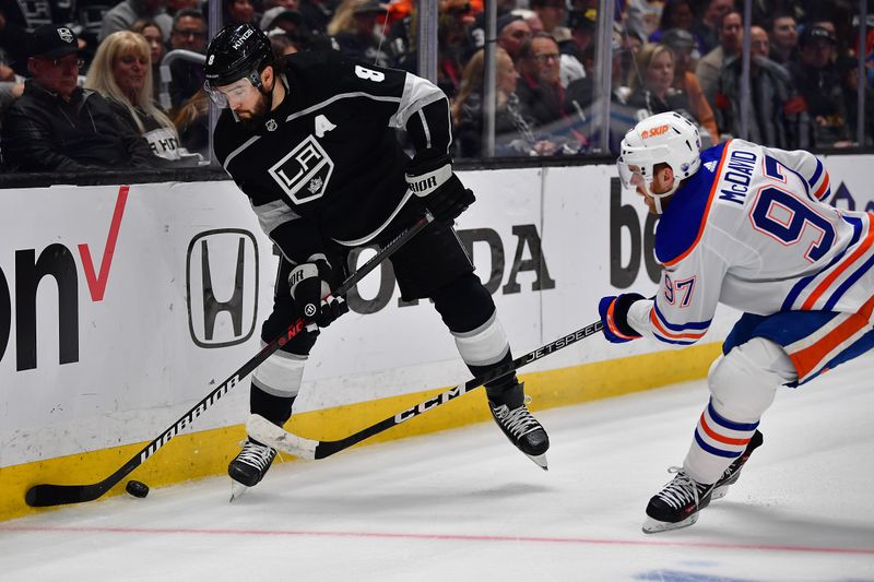 Apr 29, 2023; Los Angeles, California, USA;Los Angeles Kings defenseman Drew Doughty (8) moves the puck against Edmonton Oilers center Connor McDavid (97)  during the first period in game six of the first round of the 2023 Stanley Cup Playoffs at Crypto.com Arena. Mandatory Credit: Gary A. Vasquez-USA TODAY Sports