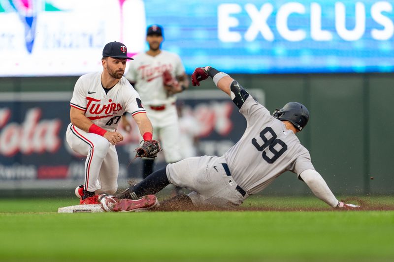 May 15, 2024; Minneapolis, Minnesota, USA; New York Yankees center fielder Aaron Judge (99) slides safe to second base as Minnesota Twins second base Edouard Julien (47) applies the tag in the third inning at Target Field. Mandatory Credit: Matt Blewett-USA TODAY Sports