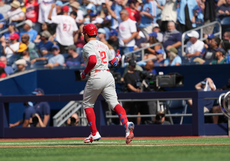 Sep 4, 2024; Toronto, Ontario, CAN; Philadelphia Phillies left fielder Kyle Schwarber (12) gives the thumbs up to the dugout after hitting home run against the Toronto Blue Jays during the first inning at Rogers Centre. Mandatory Credit: Nick Turchiaro-Imagn Images