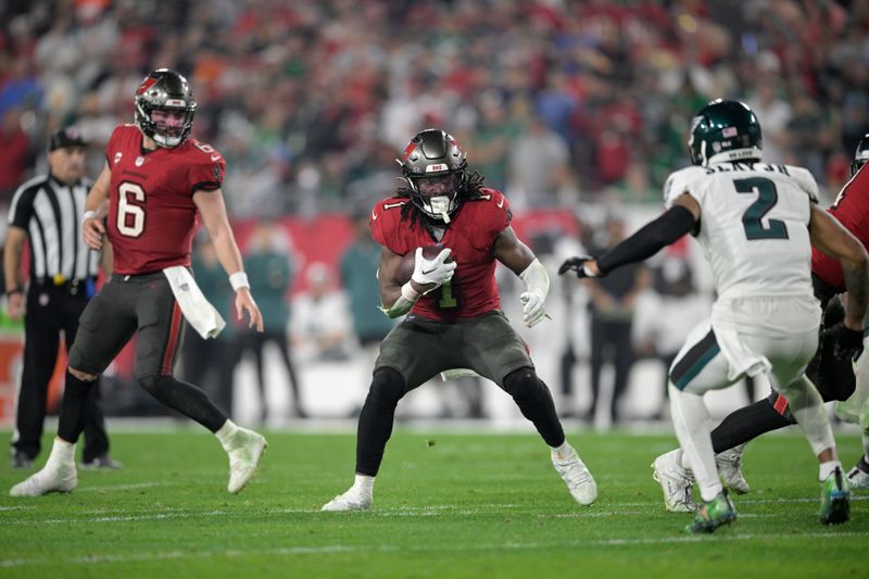 Tampa Bay Buccaneers running back Rachaad White (1) rushes for yardage in front of Philadelphia Eagles cornerback Darius Slay (2) during the second half of an NFL wild-card playoff football game, Monday, Jan. 15, 2024, in Tampa, Fla. (AP Photo/Phelan M. Ebenhack)