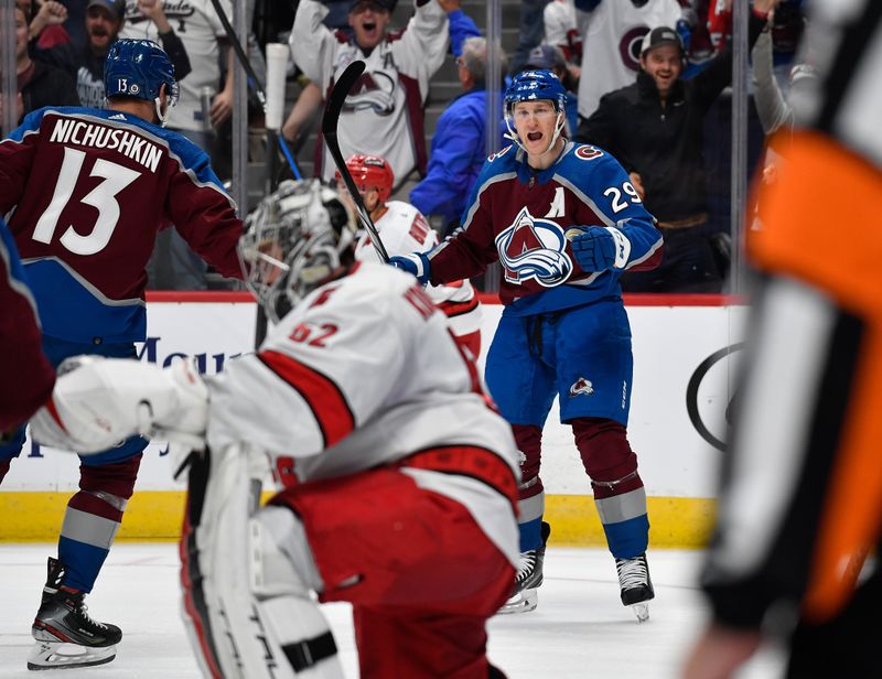 Oct 21, 2023; Denver, Colorado, USA; Colorado Avalanche center Nathan MacKinnon (29) celebrates his goal with Colorado Avalanche right wing Valeri Nichushkin (13) as Carolina Hurricanes goaltender Pyotr Kochetkov (52) kneels dejected in the second period at Ball Arena. Mandatory Credit: John Leyba-USA TODAY Sports