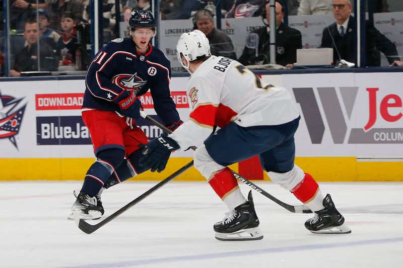 Mar 20, 2025; Columbus, Ohio, USA; Columbus Blue Jackets center Kent Johnson (91) looks to pass as Florida Panthers defenseman Tobias Bjornfot (2) de4fends during the second period at Nationwide Arena. Mandatory Credit: Russell LaBounty-Imagn Images