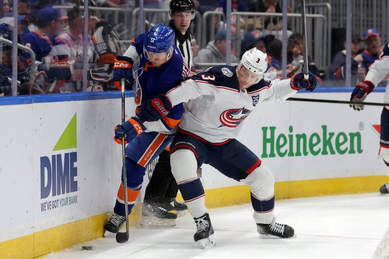 Mar 22, 2026; Elmont, New York, USA; New York Islanders left wing Emil Heineman (51) fights for the puck against Columbus Blue Jackets center Charlie Coyle (3) during the second period at UBS Arena. Mandatory Credit: Brad Penner-Imagn Images