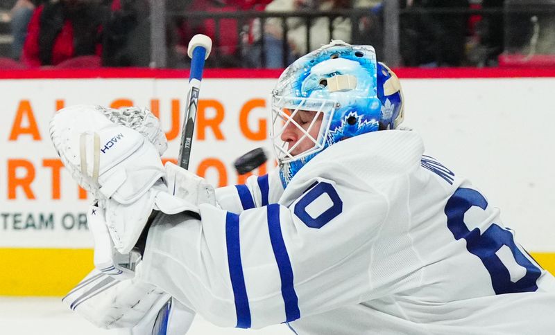 Mar 24, 2024; Raleigh, North Carolina, USA;  Toronto Maple Leafs goaltender Joseph Woll (60) makes a save against the Carolina Hurricanes during the first period at PNC Arena. Mandatory Credit: James Guillory-USA TODAY Sports