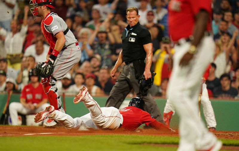 Jun 1, 2023; Boston, Massachusetts, USA; Boston Red Sox third baseman Rafael Devers (11) slides into home plate to score against the Cincinnati Reds in the fourth inning at Fenway Park. Mandatory Credit: David Butler II-USA TODAY Sports