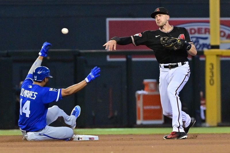 Apr 26, 2023; Phoenix, Arizona, USA; Kansas City Royals left fielder Edward Olivares (14) is out as Arizona Diamondbacks shortstop Nick Ahmed (13) throws to first base in the seventh inning at Chase Field. Mandatory Credit: Matt Kartozian-USA TODAY Sports