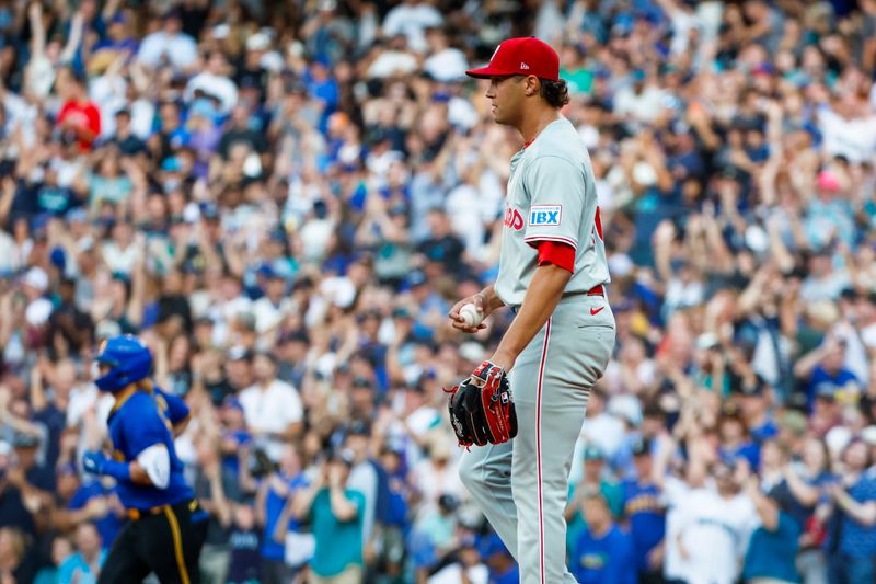 Aug 2, 2024; Seattle, Washington, USA; Philadelphia Phillies starting pitcher Tyler Phillips (48) reacts after surrendering a grand-slam home run to Seattle Mariners designated hitter Justin Turner (2, background) during the second inning at T-Mobile Park. Mandatory Credit: Joe Nicholson-USA TODAY Sports