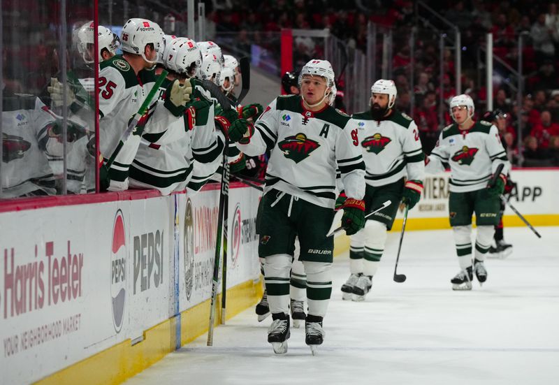 Jan 21, 2024; Raleigh, North Carolina, USA; Minnesota Wild left wing Kirill Kaprizov (97) is congratulated after his goal against the Carolina Hurricanes during the first period at PNC Arena. Mandatory Credit: James Guillory-USA TODAY Sports